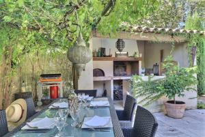 サン・カナにあるCharming Provence Retreat with Heated Pool and Jacuzziの裏庭のテーブルと椅子(キッチン付)