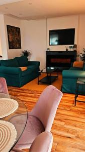 StrahoninecにあるMella holiday homeのリビングルーム(緑のソファ2台、薄型テレビ付)