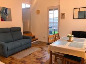 a living room with a couch and a table at Petite maison avec terrasse in Jurançon