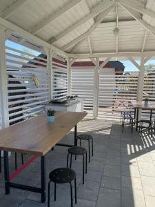 a patio with a wooden table and some chairs at Domki Wśród Jabłoni in Gąski