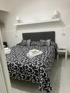 una camera con un letto bianco e nero con due cuscini di Le 3 Sorelle House a Napoli