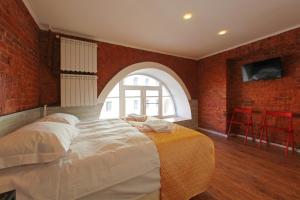 a bedroom with a large bed with a brick wall at Amore in Saint Petersburg