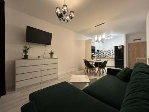 a living room with a couch and a dining room at Apartament nad Iławką 28 in Iława