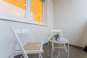 2 sillas blancas, una mesa y una ventana en Flex SelfCheckIns 138 - Zagreb - Bedroom - Parking - Loggia, en Zagreb 20 fotos más