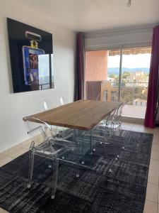 ein Esstisch und Stühle in einem Wohnzimmer in der Unterkunft Appartement vue sur le golfe d ajaccio in Ajaccio