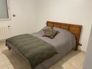 ein Bett mit einem hölzernen Kopfteil in einem Schlafzimmer in der Unterkunft Appartement vue sur le golfe d ajaccio in Ajaccio