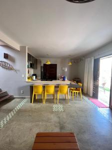 Una sala de estar con una mesa y sillas amarillas. en Bangalôs da Barra Chalé 2, en Barra Grande 22 fotos más