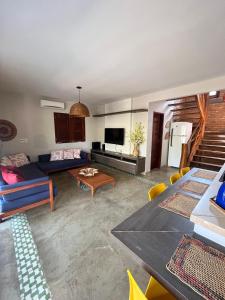 Una sala de estar con un sofá azul y una mesa. en Bangalôs da Barra Chalé 2, en Barra Grande