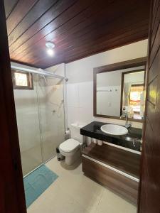 Un baño con inodoro, lavabo y espejo. en Bangalôs da Barra Chalé 2, en Barra Grande