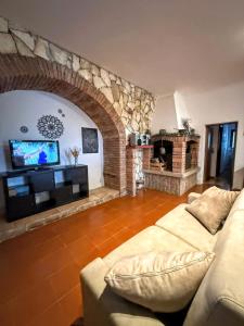 a living room with a couch and a stone fireplace at Karma Rural Buenavista in Santa Marinella +167 photos