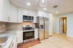 een keuken met witte kasten en een roestvrijstalen koelkast bij Tranquil Days in Bradenton