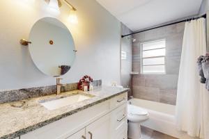 een badkamer met een wastafel, een toilet en een spiegel bij Tranquil Days in Bradenton +12 foto's