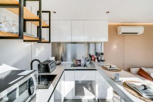 a kitchen with white cabinets and a counter top at 8 Mi to Lake Access Futuristic Capsule Hideaway! in Valley View +16 photos