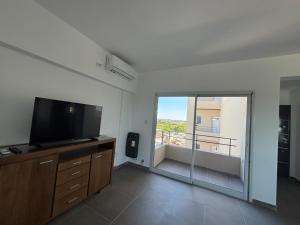 a living room with a flat screen tv and a balcony at Harmony Center Junin in Junín