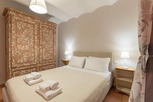 una camera da letto con un letto con due asciugamani sopra di S.Ambrogio Courtyard in Florence-hosted by Thinah a Firenze