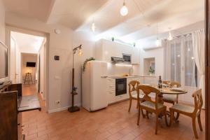una cucina con un tavolo e un frigorifero bianco di S.Ambrogio Courtyard in Florence-hosted by Thinah a Firenze