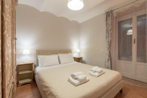 una camera da letto con un letto con due asciugamani sopra di S.Ambrogio Courtyard in Florence-hosted by Thinah a Firenze