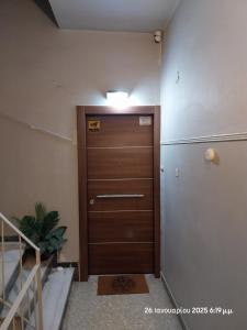 einen Flur mit Holztür in einem Zimmer in der Unterkunft Cozy & Bright Home - 50m from metro station Άg Antonios in Athen