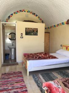 una camera da letto con un letto in una stanza di Nubian Beach - حسن فوكس a Aswan