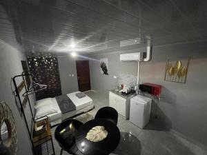 a room with a bed and a table and chairs at Nice Studio Flore in Saint-Laurent du Maroni