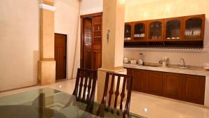 a kitchen with a glass table and wooden cabinets at Casa Näab Centro de Merida in Mérida +22 photos