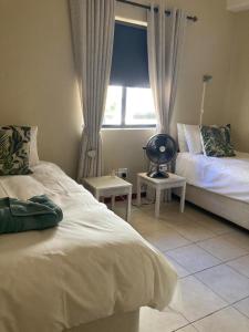a bedroom with two beds and a window at SEASCAPE MEWS 27 in Cape Town