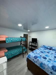 a bedroom with two bunk beds and a television at San Angel in La Loma