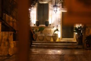 a hallway with potted plants and a window at La Cortese, cuore barocco in Noto