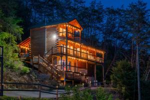 a tree house in the woods at night at Heavenly Bliss By Ghosal Luxury Lodging in Sevierville