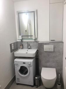 a bathroom with a washing machine and a sink at Ferienwohnung Sommerblüte in Schweich