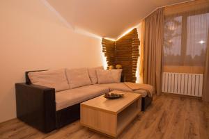 a living room with a couch and a coffee table at Borovets Gardens Aparthotel Seasons Borovets PM in Borovets