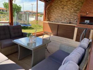 a patio with a couch and a table and a kitchen at Villa Bacchus in Nikiti