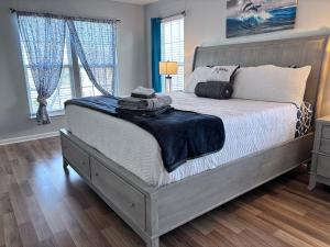 a bedroom with a large bed with a wooden floor at Amazing 4 BDRM home w garage in Charlotte in Charlotte