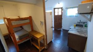 a small room with a bunk bed and a kitchen at Mile y Luci in San Clemente del Tuyú