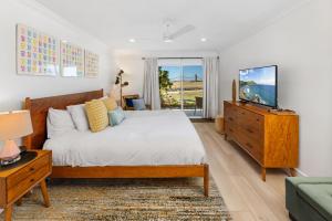 a bedroom with a bed and a tv on a dresser at Happy Days - SBTC101 in Solana Beach
