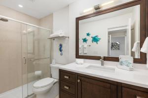 a bathroom with a toilet and a sink and a mirror at Happy Days - SBTC101 in Solana Beach +19 photos
