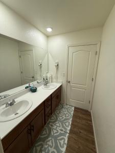 Un baño con dos lavabos y un espejo grande. en #stayRioVista Farmhouse near river- Entire House with RV parking, en Rio Vista 129 fotos más