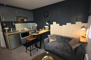 a living room with a couch and a kitchen at L'Appart - Résidence Chez Gally à Angers in Les Ponts-de-Cé