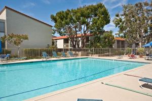 a large swimming pool with chairs and trees at Paradise Found! - SBTC336 in Solana Beach