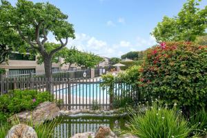 a garden with a fence and flowers and a pool at Bella Vista - SUR111 in Solana Beach