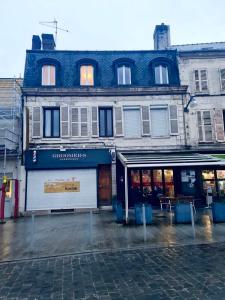 a building on a city street with a store at Un appartement en centre ville , à 2 pas du château de Villers Cotterets in Villers-Cotterêts