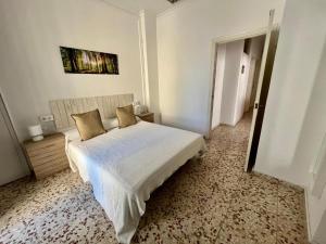 a bedroom with a white bed with two pillows at La Casa de la Plaza Vieja in Estepona