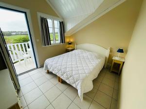 ein Schlafzimmer mit einem Bett und einem Balkon in der Unterkunft "LE VENDEE GOLF" Appartement 8 personnes, vue golf, accès piscines gratuit, village vacances in Talmont + 24 Fotos
