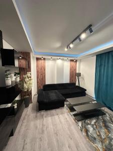 een woonkamer met een zwarte bank en een tafel bij Rezidențial 1 in Baia Mare