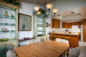 a kitchen with a wooden table and a dining room at Escape at Seascape - SUR112 in Solana Beach