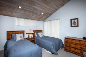 a bedroom with two beds and a wooden ceiling at Escape at Seascape - SUR112 in Solana Beach