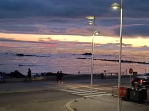 a group of people walking on the beach at sunset at Cachinnans Hostel & Apartments in Vila do Conde +10 photos