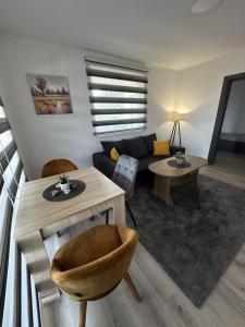 a living room with a couch and a table at Ammirevole Ravne Apartments in Visoko