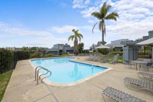 una piscina con sillas y palmeras en Vista Pacific - DM1050, en Del Mar