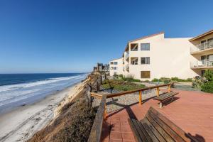 a building next to the beach with a bench at Once Upon A Tide - SBTC312 in Solana Beach